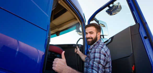 professional truck driver entering his truck long vehicle and holding thumbs up scaled